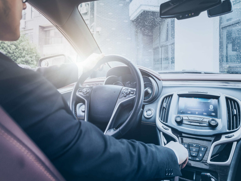 detail shot of young businessman driving his car.